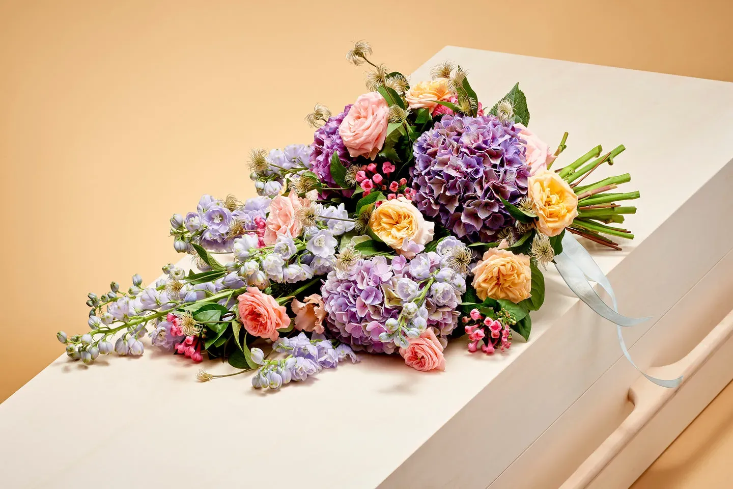 Kleurrijk rouwboeket met rozen, hortensia en seizoensbloemen