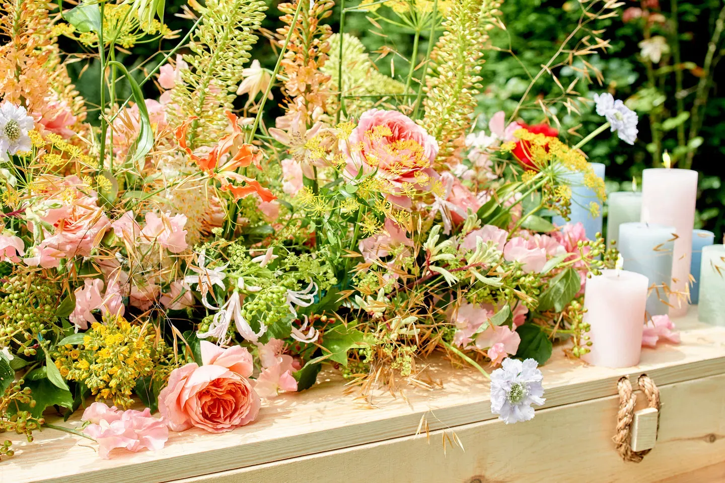 Kistbedekking met rozen en seizoensbloemen op een witte kist